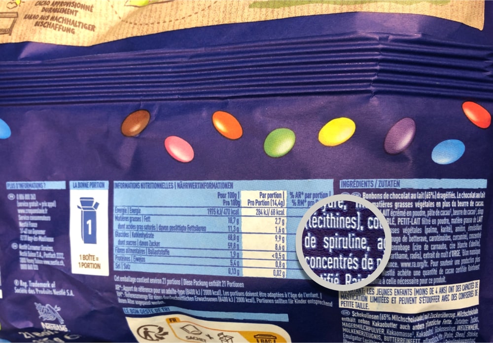 Sachet de Smarties, zoom sur la liste d'ingrédients et le colorant spiruline